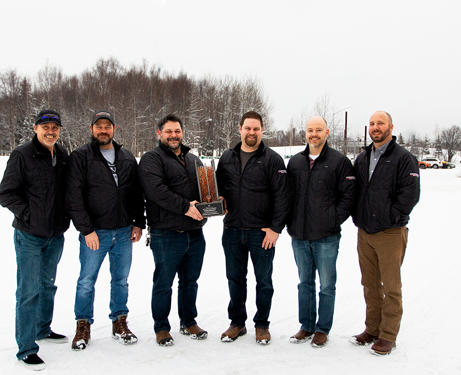 men standing in snow accepting award for Cornerstone General Contractors, Inc.