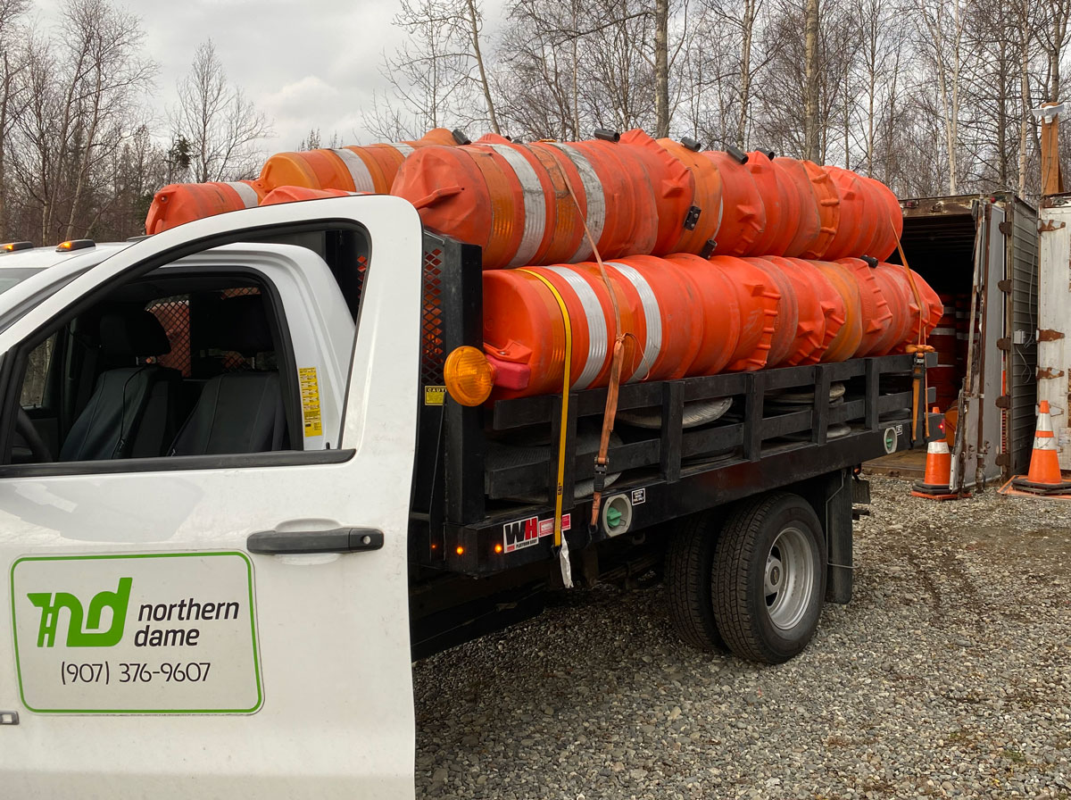 A Northern Dame Construction truck is loaded with drums for earthquake repair on Clark-Wolverine in Palmer