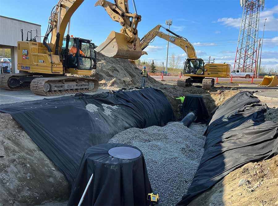 Caliber Construction workers use a Topcon MC-Max Automatic Excavator System to make site improvements at the Carrs on DeBarr Road in Anchorage