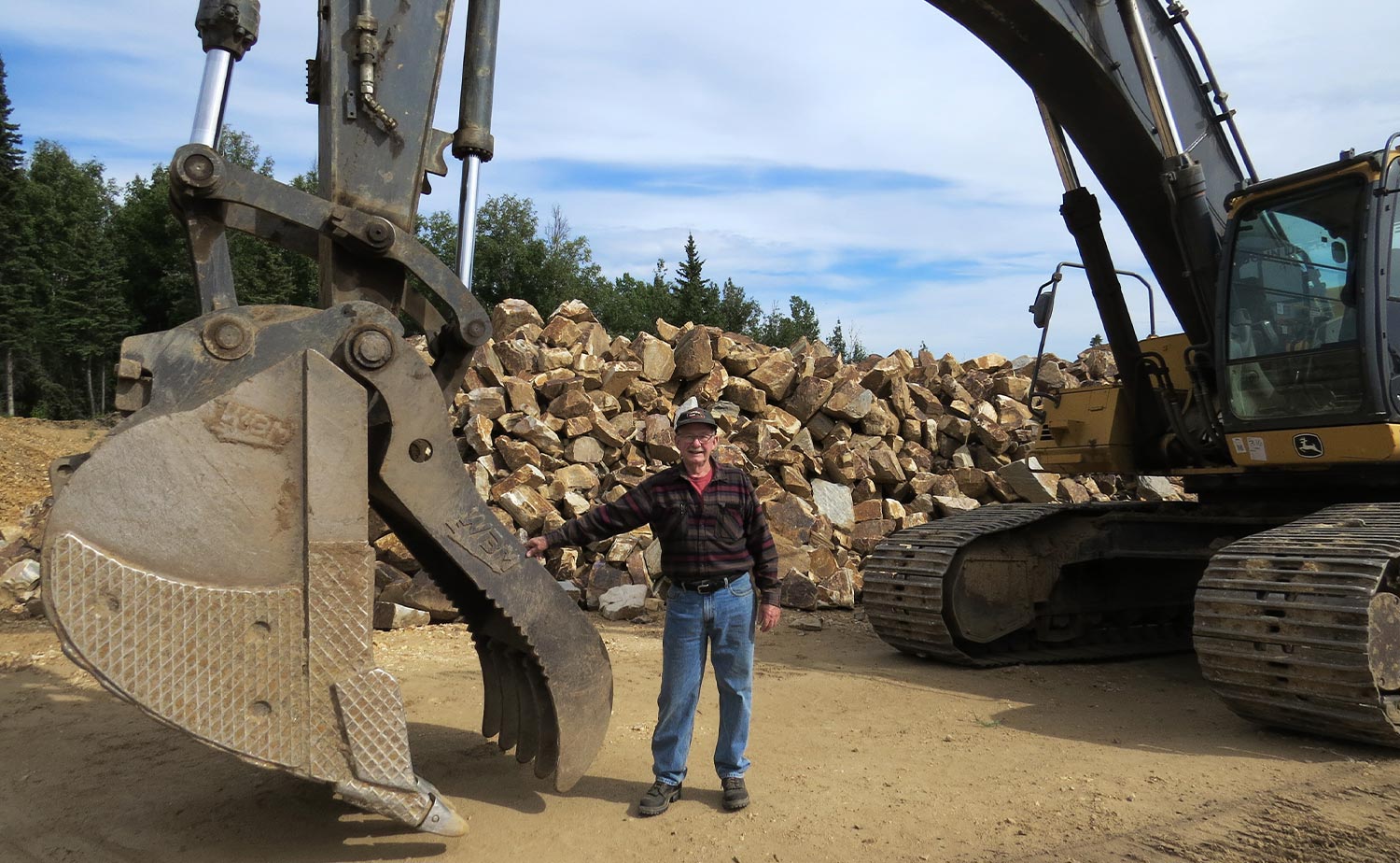 Wayne Carpenter stands by a large earth moving tractor at his Shaw Creek quarry