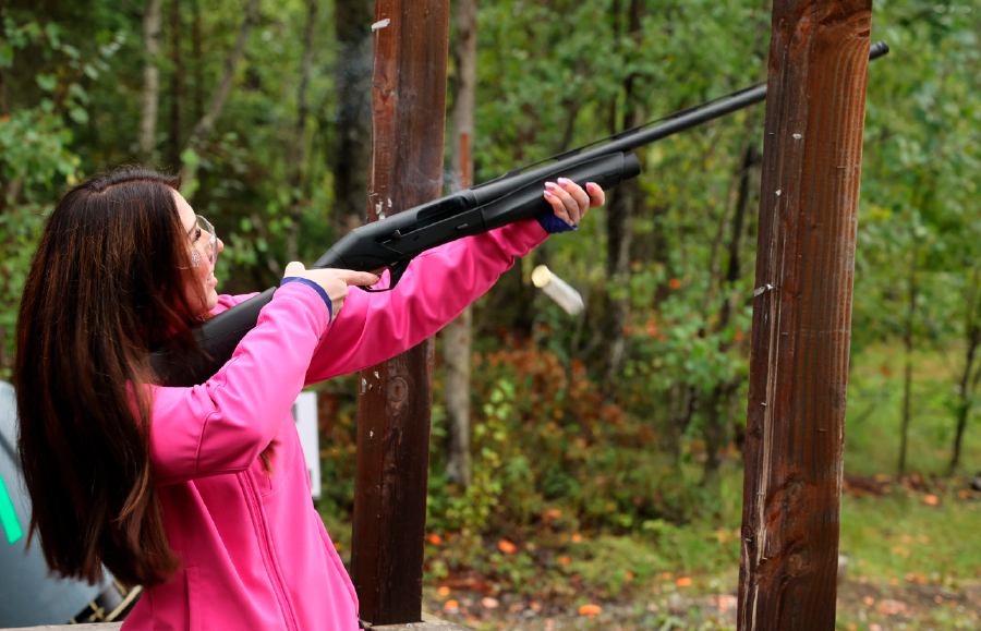 woman aiming gun in the woods