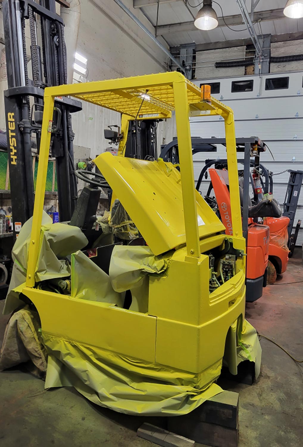 a forklift in the middle of a bright yellow paint job