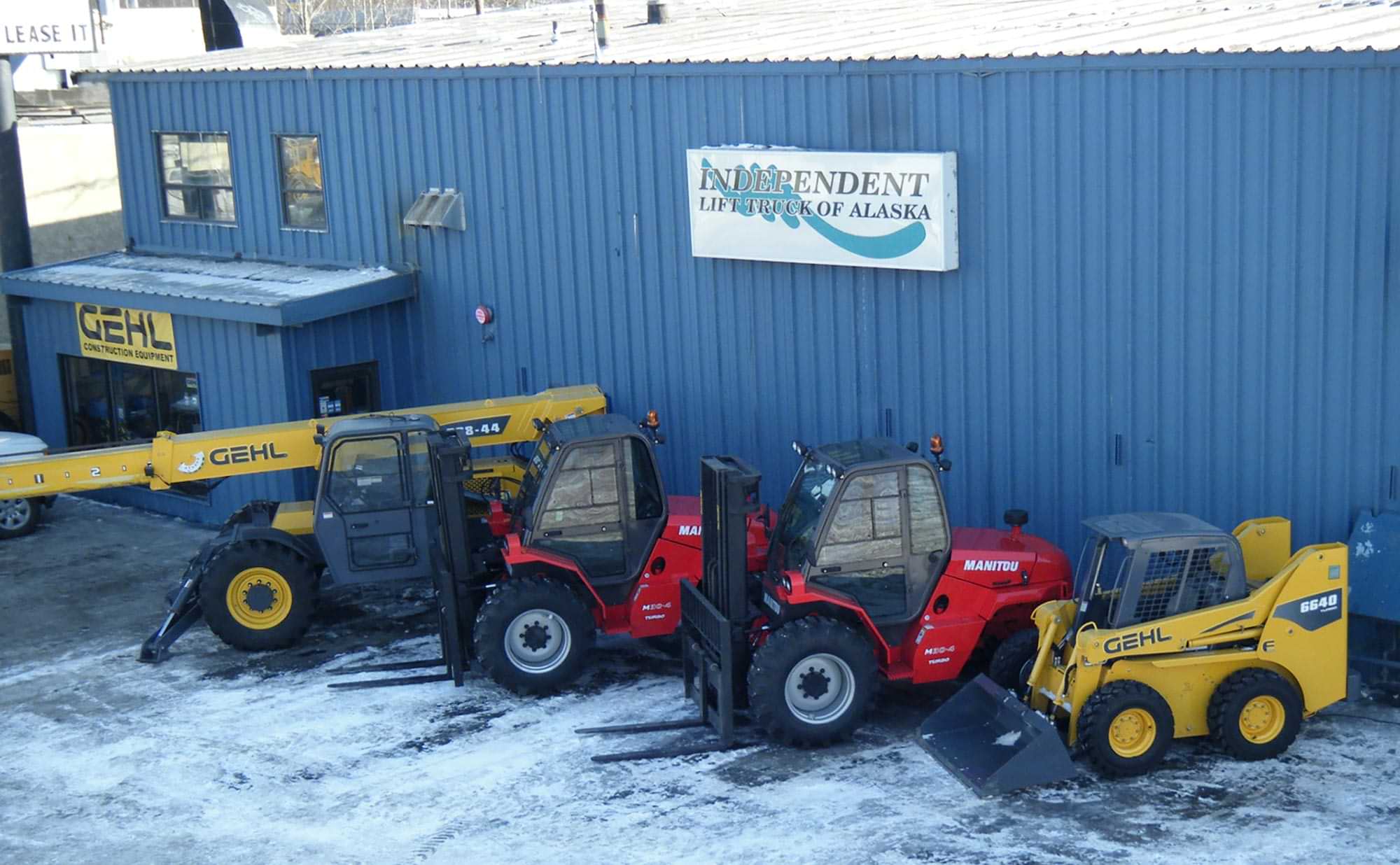 two forklifts and two rough terrain machines parked in front of the ILT Alaska dealership