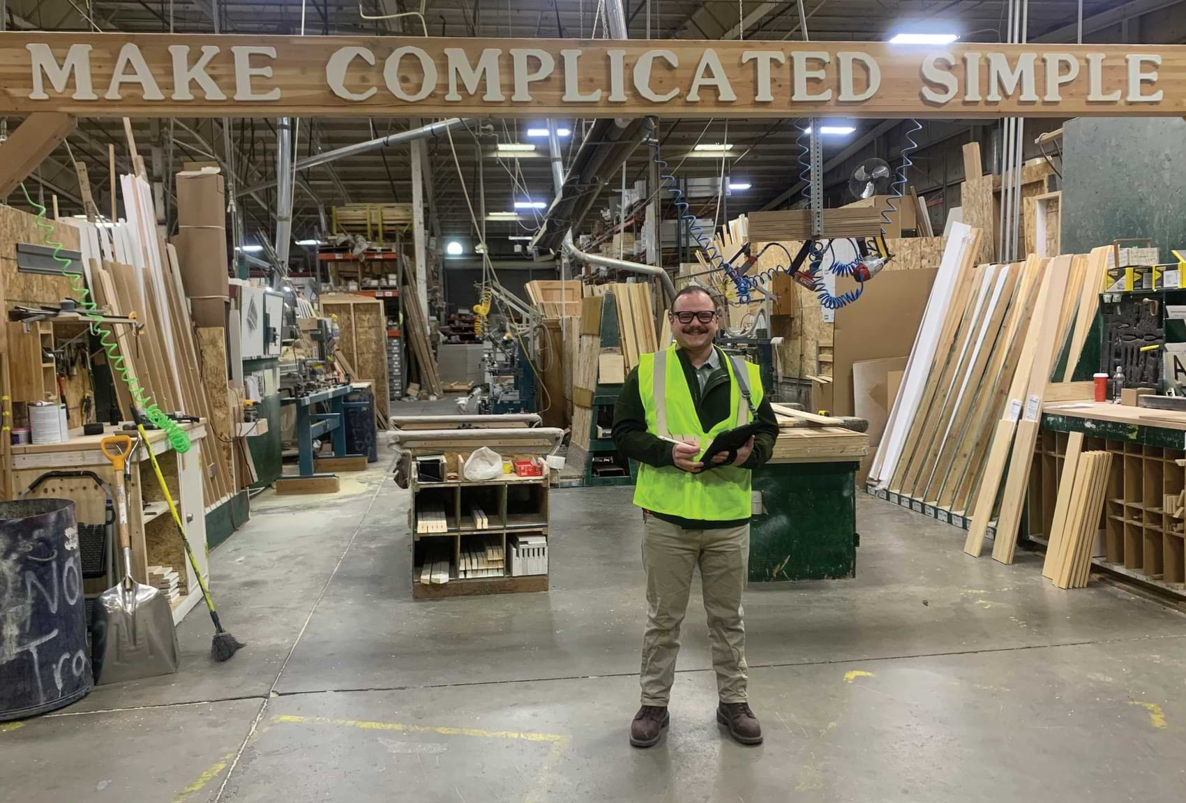 Jackson Waste standing underneath a sign emblazoned with the company’s mission, “Make Complicated Simple”