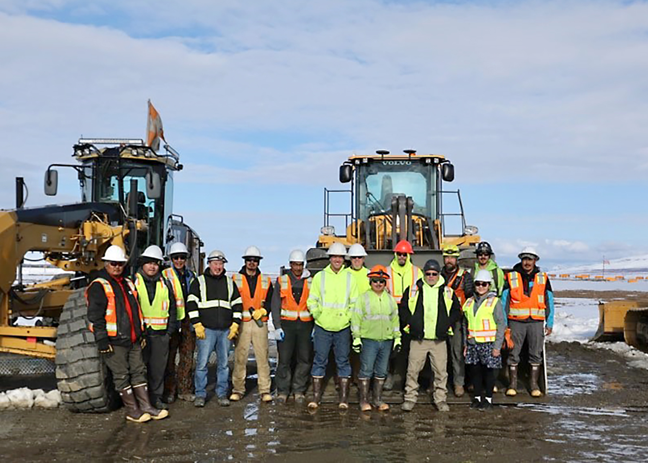 Drake Construction crew members in front of motor grader and bulldozer
