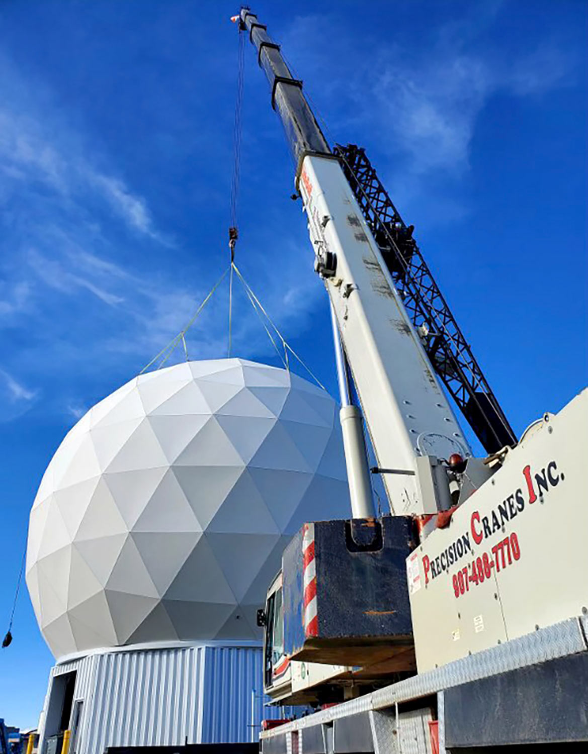 a Precision Crane is operated while rigged to the radome of the Alaska Satellite Facility, in 2020