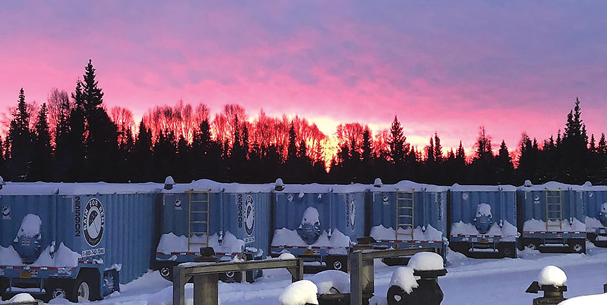 Line of trailer tanks in the snow during at sunset