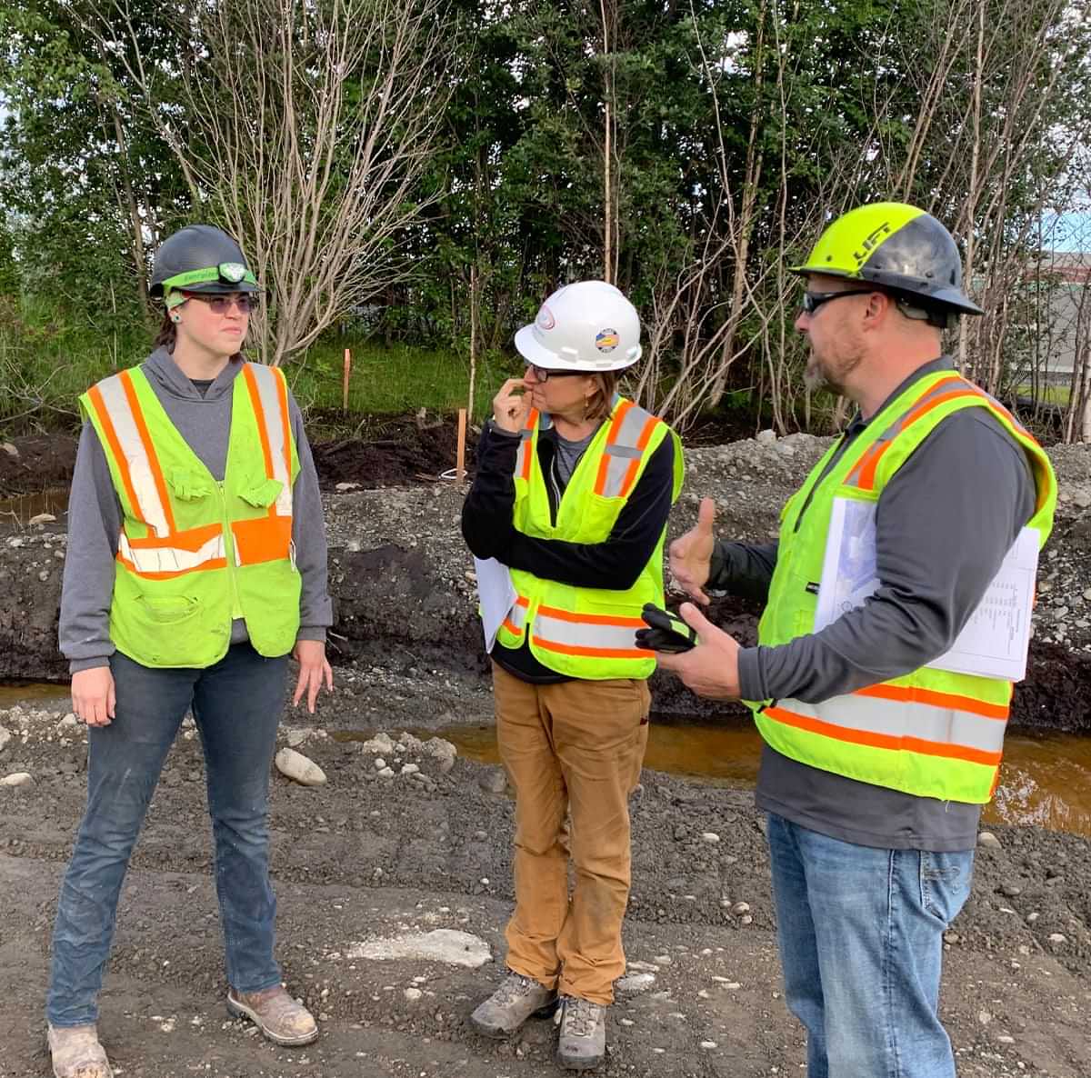 teachers Molly Suoja and Jenne Denton and QAP area manager Kris Jensen stand at a job site during Associated General Contractors of Alaska's Educator Externship