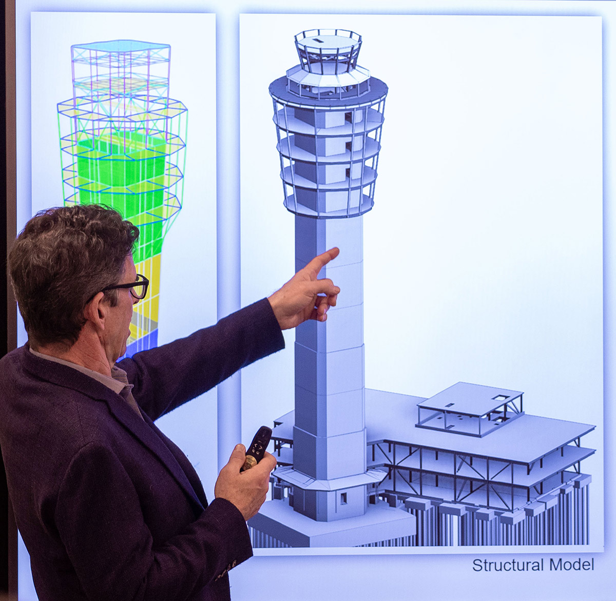 Man pointing to an architectural model on a projector screen