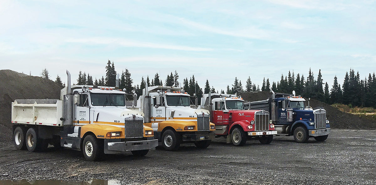 Four dump trucks at gravel pit