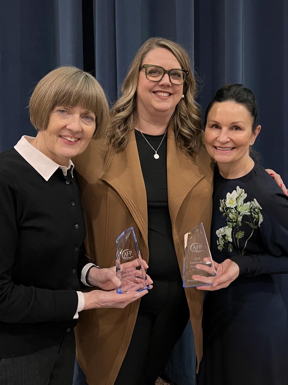 members of GHEMM Co. and Meg Nordale posing for a photo while holding awards