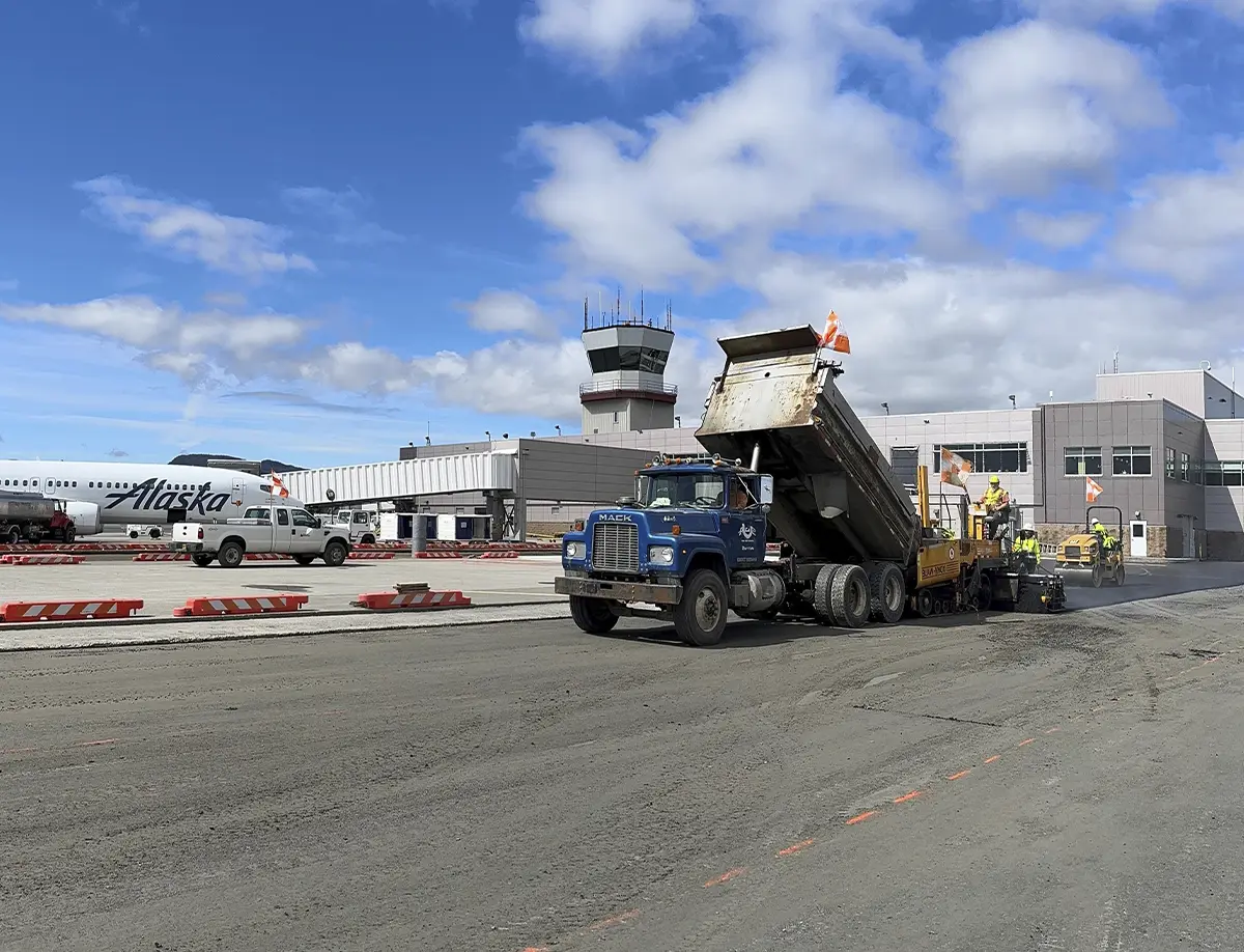 truck dumping asphalt onto a road