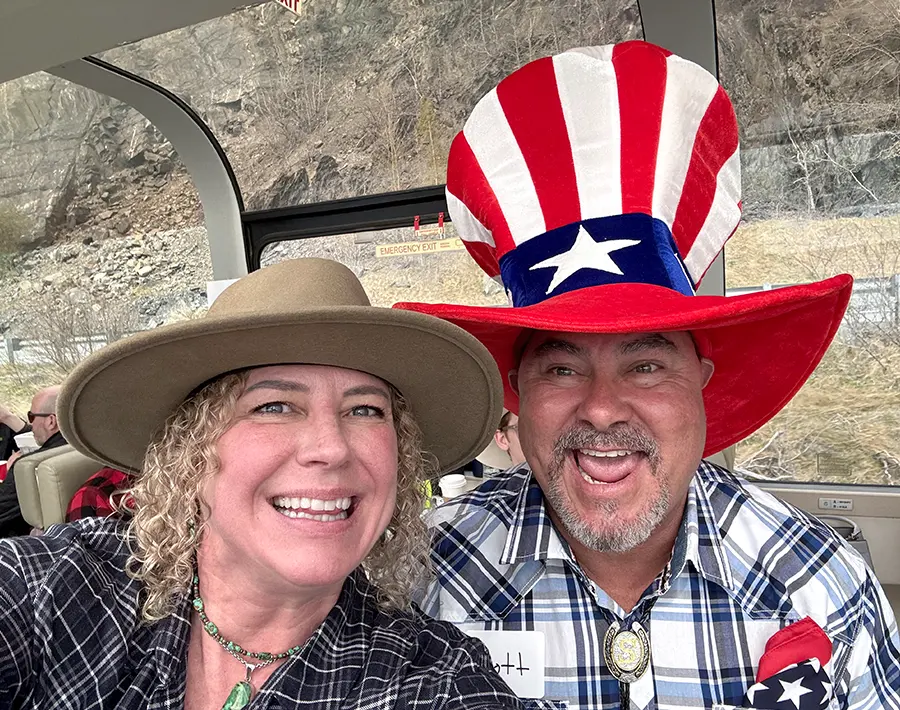a woman and a man wearing a large patriotic hat smiling