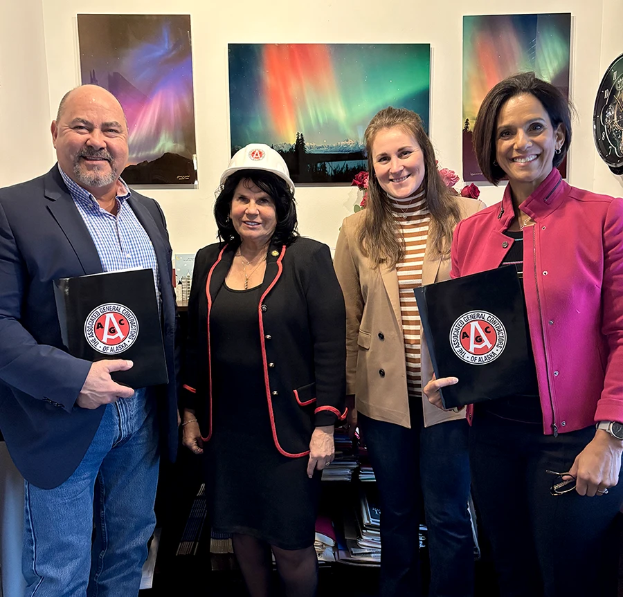 four people in an office holding AGC folders