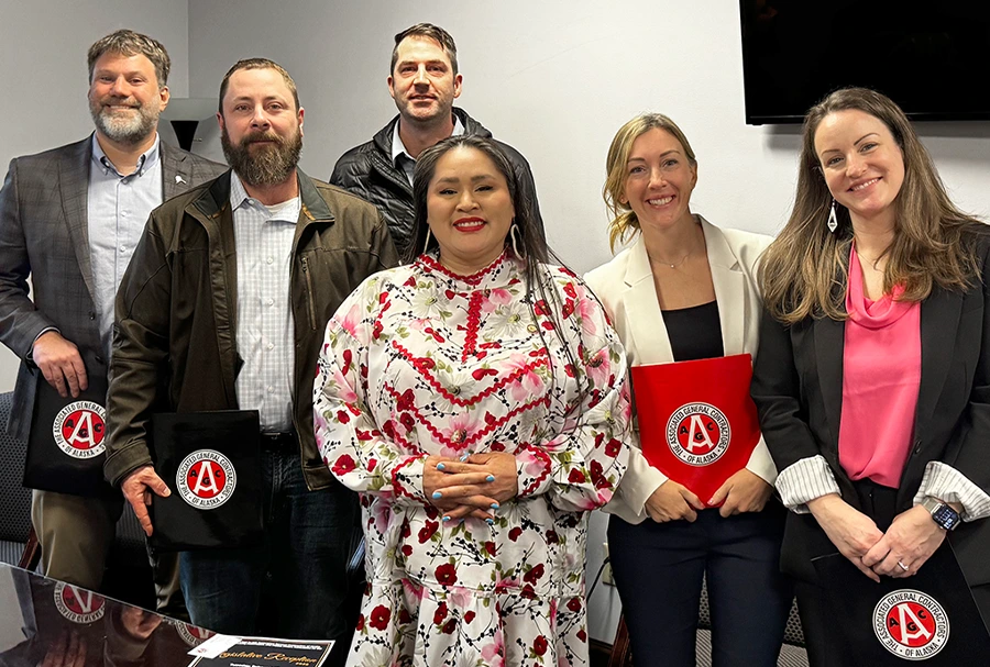 six people in an office holding AGC folders