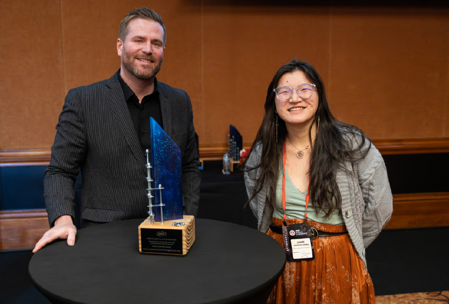 Matt Thon and Jamie Murphy Soika standing next to award