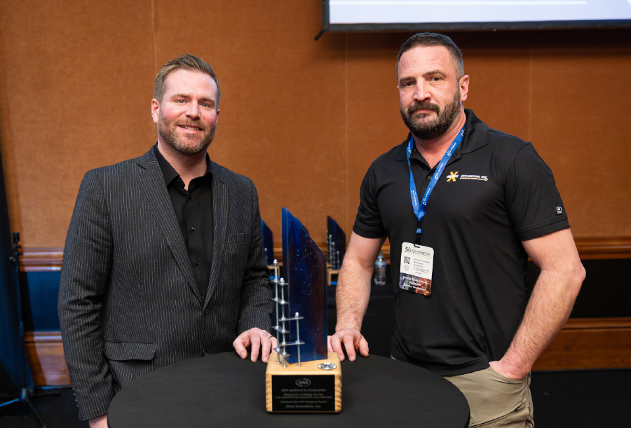 Matt Thon and Justin Shields standing next to award