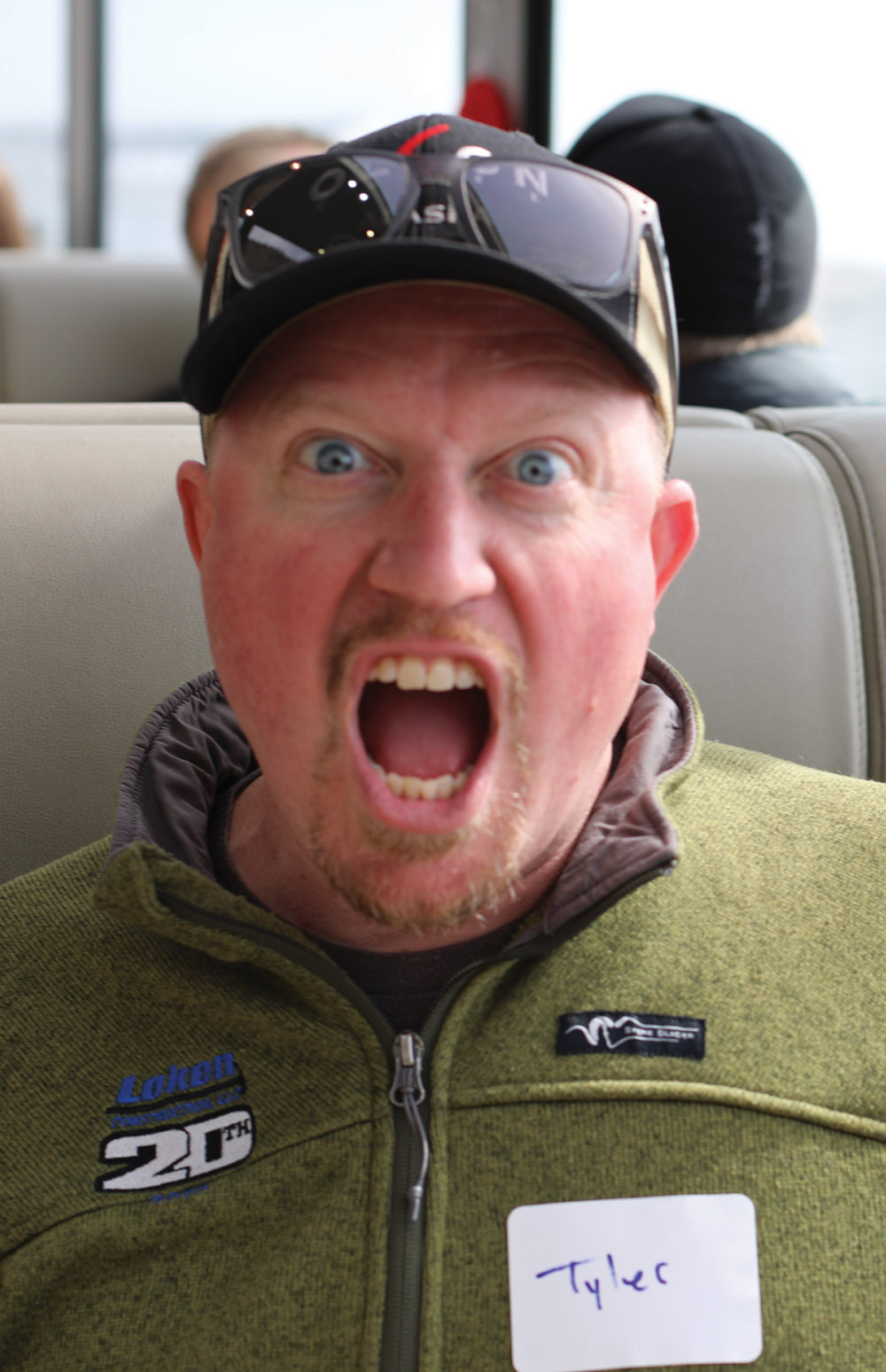 Close-up of a man named Tyler making a funny, wide-mouthed shocked expression while wearing a green fleece.
